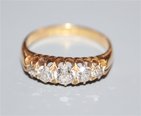 A late Victorian 18ct gold and graduated five stone diamond half hoop ring, size P.